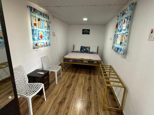 a room with a bed and two chairs in it at TOMS' Cabin Farmhouse in Chauk