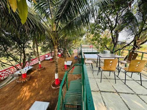 a restaurant with tables and chairs and a palm tree at TOMS' Cabin Farmhouse in Chauk