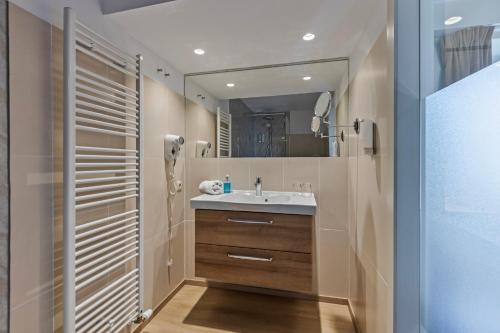 a bathroom with a sink and a mirror at Hotel Brasserie de Klok in Zutendaal