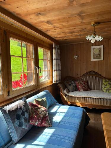 a living room with a couch and two windows at Bräkerhaus Toggenburg in Lichtensteig