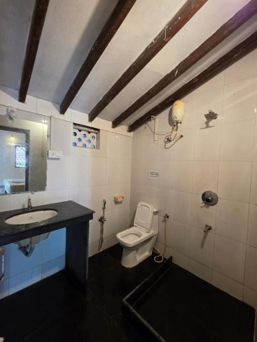 a bathroom with a toilet and a sink at Joe Banana Stays in Anjuna