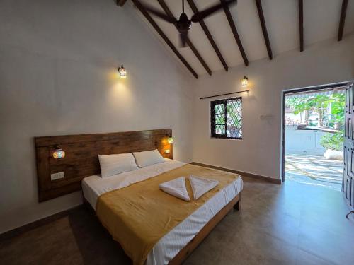 a bedroom with a large bed and a large window at Joe Banana Stays in Anjuna