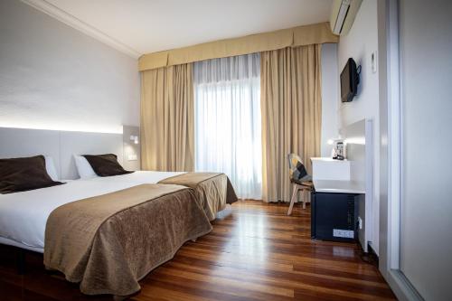 a hotel room with a bed and a television at Tudanca Miranda in Miranda de Ebro
