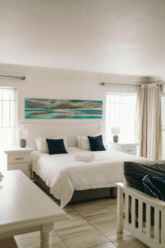 a bedroom with two beds and a painting on the wall at Summer House B&B in Gqeberha