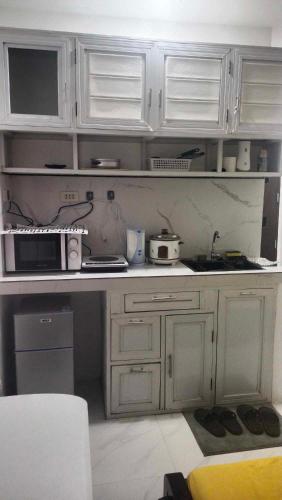 a kitchen with white cabinets and a counter top at Jessa's Transient Studio with Balcony in Masbate