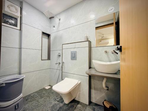 a white bathroom with a sink and a toilet at Hotel Kavita Inn in Ujjain