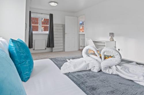 two towel swans sitting on a bed in a room at Ideal Budget Contractor Stay - 4B Home w en-suites in Great Sankey