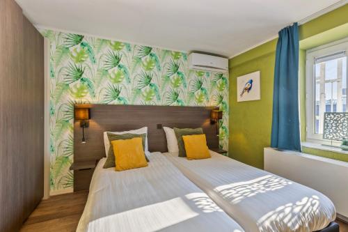 a bedroom with two beds and green walls at Hotel Brasserie de Klok in Zutendaal