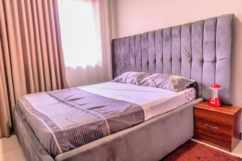a bed with a large headboard in a bedroom at EKay's Space Najjera1 in Namugongo