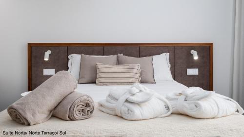 a bedroom with a bed with towels on it at Mónaco Suites & Garden in Ponta Delgada