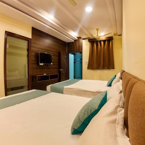 a hotel room with two beds and a tv at Olive Hotel in Hyderabad