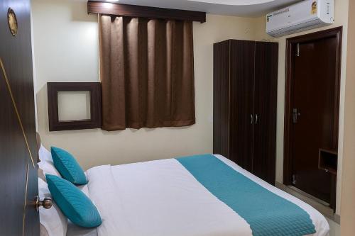 a bedroom with a bed with blue pillows at Olive Hotel in Hyderabad
