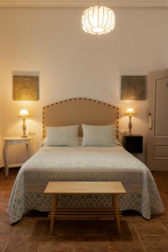 a bedroom with a bed and two lamps and a chandelier at Rompeolas Playa in Chipiona