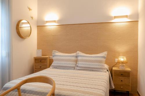 a bedroom with a bed and a chair and a mirror at Rompeolas Playa in Chipiona