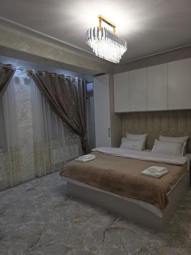 a bedroom with a large bed and a chandelier at Guest house 2 in Fergana
