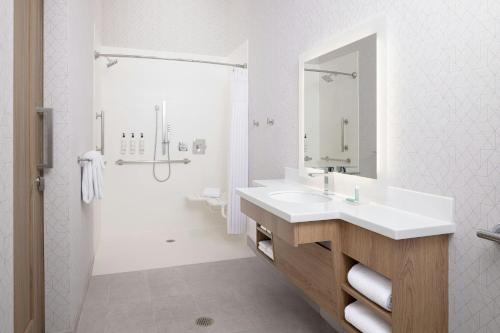 a white bathroom with two sinks and a shower at SpringHill Suites by Marriott Atlanta Covington in Covington