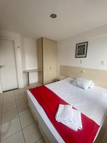 a bedroom with a large bed with a red blanket at Silva Hospedagem AMERICAN FLAT BEIRA MAR apartamento por temporada in São Luís