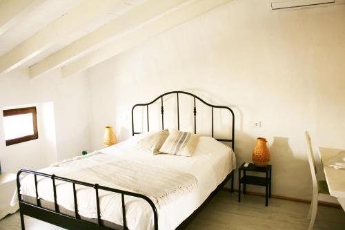 a bedroom with a large bed in a white room at Stadthaus Ca Sa Batlessa in Arta in Artá