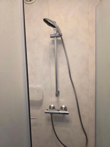 a shower with a shower head in a bathroom at Center Appartement Apeldoorn in Apeldoorn