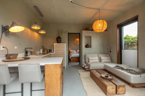 a kitchen and living room with a couch and a table at PUUR aan de Zeeuwse kust in Wemeldinge