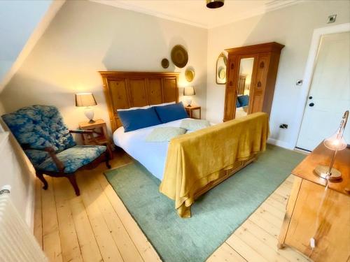 a bedroom with a bed and a chair at Room 3, Wedale House in Stow