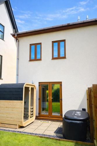 a house with a wooden front door and a yard at Luxury 3 Bedroom Welsh Valley Retreat With Superfast Wifi in Tredegar