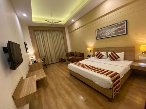 a hotel room with a bed and a television at Hotel KC Cross Road Panchkula in Panchkula