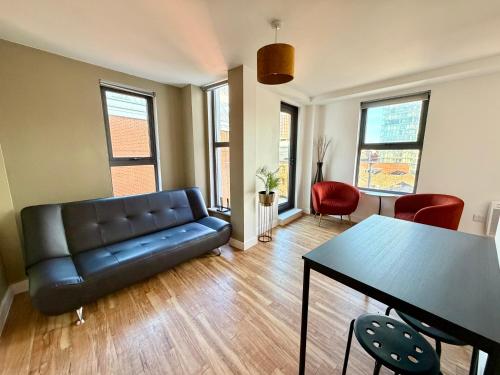 a living room with a couch and a table at City Centre 2 bed apartment with a balcony in Manchester
