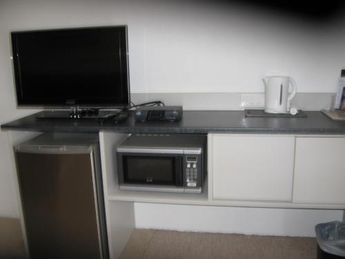 a desk with a microwave and a computer on it at Darlot Motor Inn in Horsham