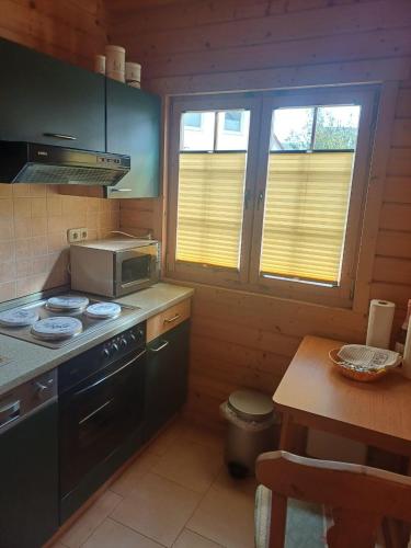 a kitchen with a stove and a microwave at Holiday Home Fleesensee in Göhren-Lebbin