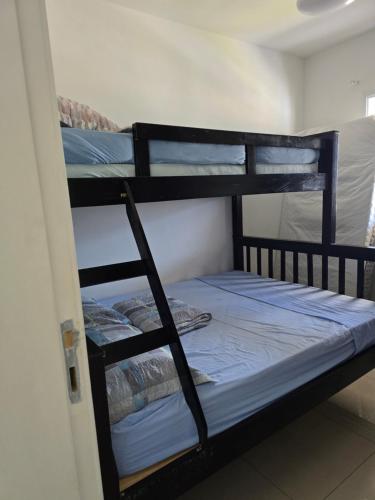 a couple of bunk beds in a room at Apartamento confortável no Centro in Bertioga
