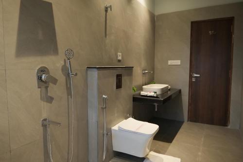 a bathroom with a shower and a toilet and a sink at WelcomHeritage Mount Valley Resort Ranthambore in Sawāi Mādhopur