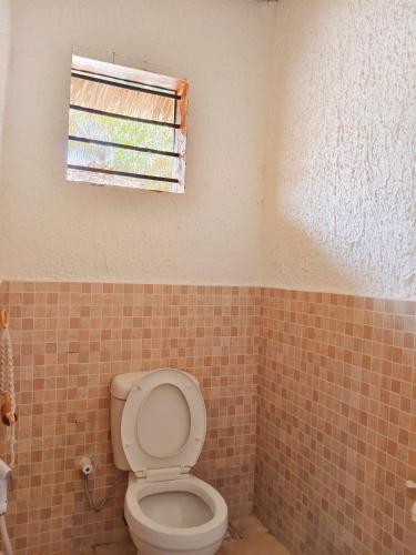 a bathroom with a toilet and a window at Sawa Sawa Beach Hotel&Backpacks in Malindi