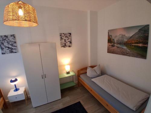a small bedroom with a bed and a refrigerator at Geräumige Stadtwohnung mit Balkon in Zwickau