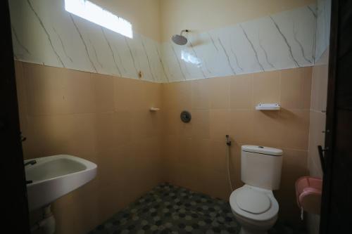 a bathroom with a white toilet and a sink at Tiffany Garden in Mangsit