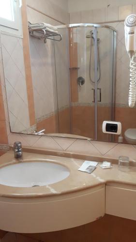 a bathroom with a sink and a shower at Hotel Grifone in Rimini
