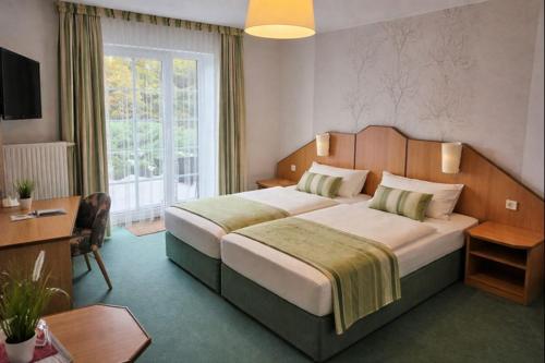a bedroom with a large bed and a large window at Richzenhainer-Hof in Waldheim