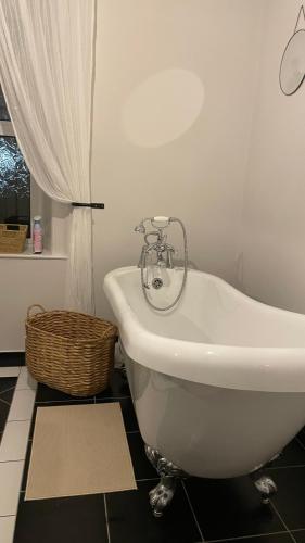 a white bath tub in a bathroom with a window at Anyas rooms Ltd in Antrim
