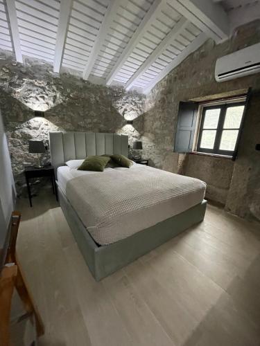 a bedroom with a bed and a stone wall at Casa Aurora in Perelhal