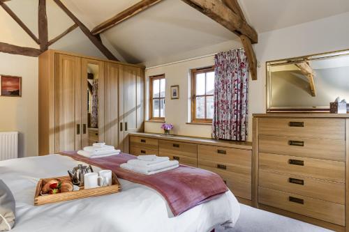 a bedroom with a large bed and wooden cabinets at Long Barn in Ludlow