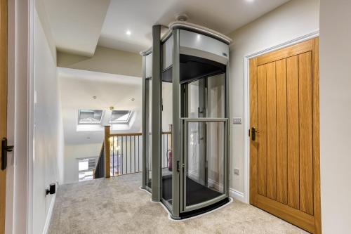 a glass elevator in a hallway next to a door at Hill Top Farm in Penrith