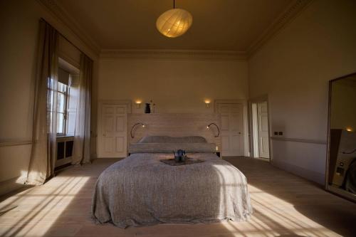 a bedroom with a bed and a lamp in it at Denton Hall in Ilkley