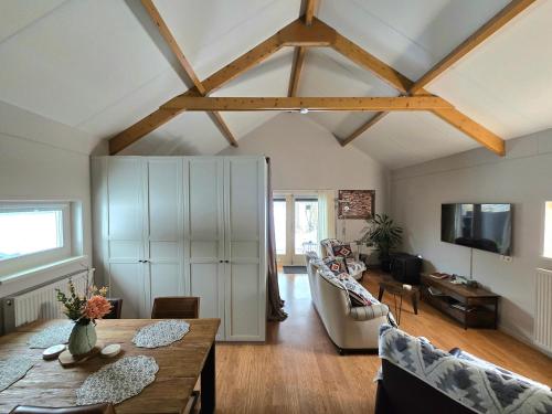 a living room with a table and chairs and a tv at Whispering O - B&B Ermelo Speuld On the Veluwe in Ermelo