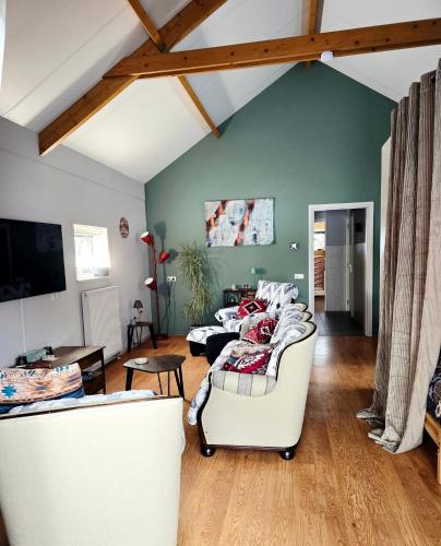 a living room with two couches and a tv at Whispering O - B&B Ermelo Speuld On the Veluwe in Ermelo