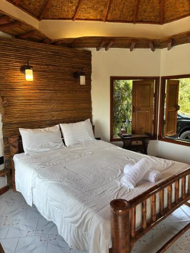 a bedroom with a large bed with a wooden headboard at The Orchid Resort & Relax in Maha Sarakham