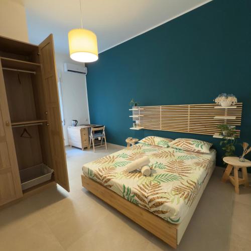 a bedroom with a bed and a blue wall at B&B Miseno23 in Bacoli