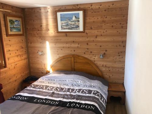 sypialnia z łóżkiem w drewnianej ścianie w obiekcie Appartement w mieście La Celle-sous-Gouzon