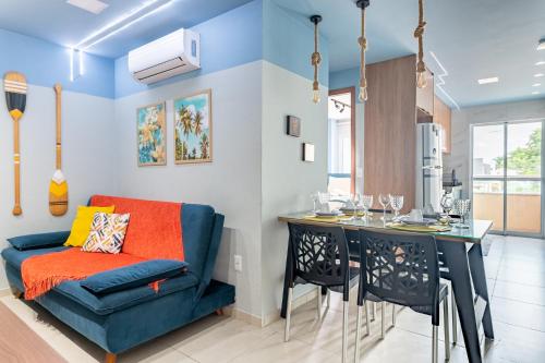 a living room with a blue couch and a table at Flat Coqueiros 101 Praia in Tamandaré