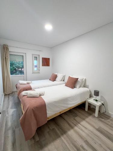two beds in a white room with at Casa Rosa in Parede