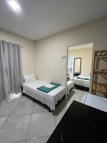 a bedroom with two beds and a large mirror at Pousada Vista da Serra - Suzart in Lençóis